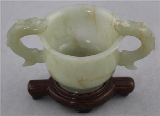 A Chinese bowenite jade two handled cup, Ming dynasty or later, 10.8cm., wood stand